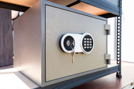 Cash Money safe deposit box. a metal safe and a key in the lock.の写真素材