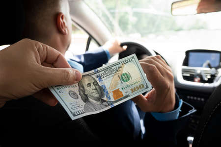 Passengers pay service fees to male taxi drivers. client pays for the trip in dollars. 100 dollar...