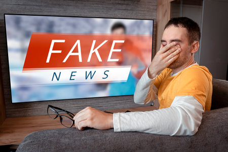 lies of tv propaganda mainstream media disinformation, A fake news report. viewer is watching TV and doesn't believe in fake news. man closes his eyes not to watch the lies on TVの写真素材