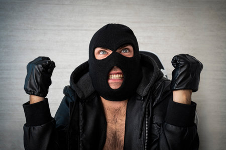 angry aggressive masked thug screams in anger.