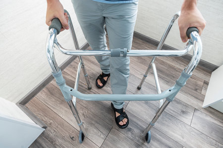 a sick person walks with the help of special devices for rehabilitation. Walkers for adults. rehabilitation after a broken leg or stroke.の写真素材