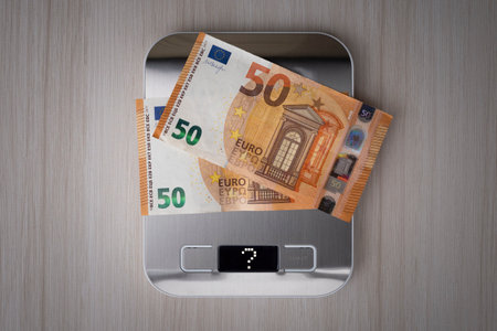 euro bills on the electronic scales, a symbol of cost reduction, inflation, depreciation of money. concept of inflation in the European Unionの写真素材