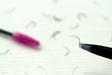 Eyebrow paint brushes, tweezers, on a beige background. The concept of beauty, eyebrows. Plucking eyebrows. Small hair eyebrow brush and tweezers on a white table. The concept of self care.の写真素材