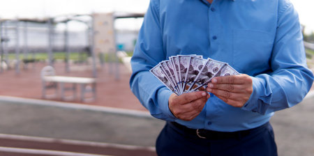 Businessman has money in his hand, stadium background. money laundering on the construction of stadiums and sports grounds concept.の写真素材