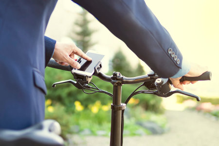 cyclist hands use gps navigator on smartphone while biking. man presses his finger on the smartphone...