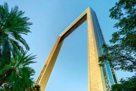 Dubai, UAE. November 25, 2022: Dubai Golden Frame best new landmark, which located in Zabeel Park. View on golden frame and palm treeのeditorial素材