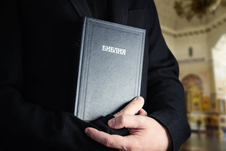 the Holy Bible in men's hands. The concept of faith and religion. christian faith. The inscription...