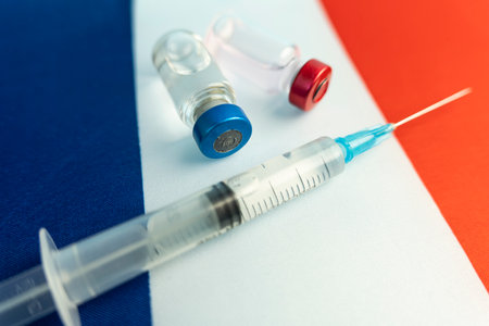 Pharmacology and Medicine France concept. vaccine against coronavirus covid. Vaccine ampoules, syringe against the background of the national flag. national pharmaceutical industry.の写真素材