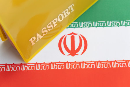 Flag of iran with passport. Travel visa and citizenship concept. residence permit in the country. a yellow document with the inscription passport is on the flag. close up, top viewの写真素材