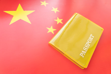 Flag of china with passport. Travel visa and citizenship concept. residence permit in the country. a yellow document with the inscription passport is on the flag. close up, top viewの写真素材