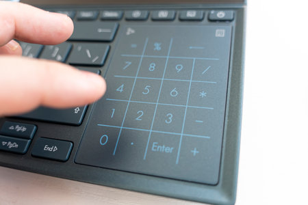 male forefinger pushes 0 NUMPAD button. Close-up VIEW. financial calculations on the laptop keyboardの写真素材