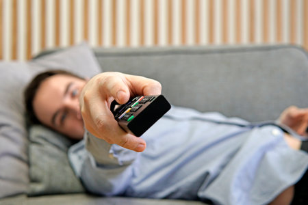 Men with the remote control front of the television. Photo toning in a retro style. switching channels.の写真素材