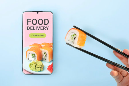 Order sushi set using mobile phone app. Online food delivery concept. order a meal in a restaurant...