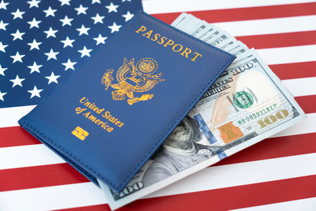 US American passport and money dollars on flag background. purchase of citizenship concept, work in the USA, loan issuance, money exchangeの写真素材