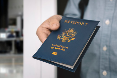hand holding passport with bokeh background, jorney and travel concept. Passport check at the border. A man will find a passport for obtaining a visa at the airport.の写真素材