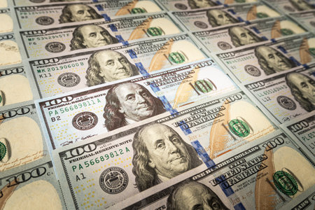 verification of the authenticity of the American banknote. search for counterfeit bills. US dollar on the background. a fake bill among real money.の写真素材