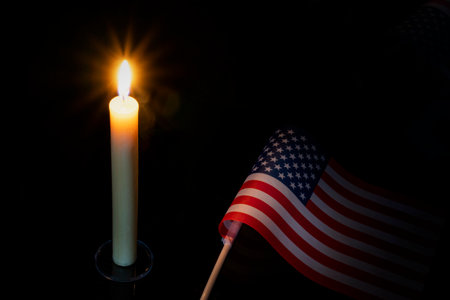 Mourning in the country united states of america. A burning candle on the background of the US flag. Victims of cataclysm or war concept. memorial day, remembrance day National mourning.の写真素材
