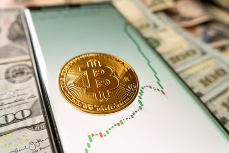 growth of the bitcoin exchange rate on the smartphone chart and the bitcoin gold coin.の写真素材