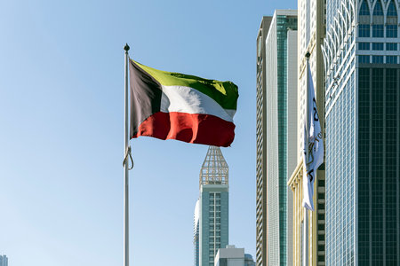 Flag waving on the background modern building, national symbol of United Arab Emirates. National Day...