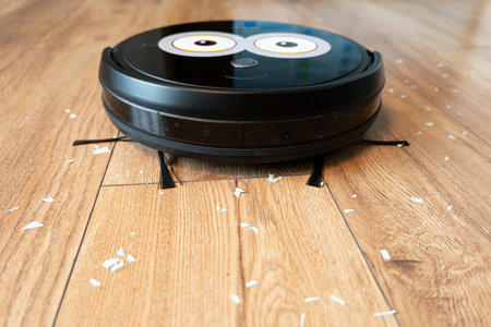 Robotic vacuum cleaner on laminate wood floor smart cleaning technology.の写真素材