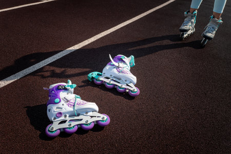 white roller skates lie on the track against the background of a roller and a shadow