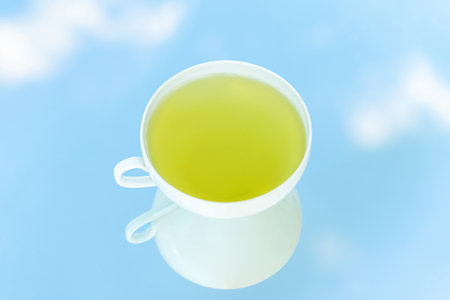 A Cup of green tea on blue background. Cleansing or detox tea is a good option for weight loss. Antioxidant properties. Copy spaceの写真素材