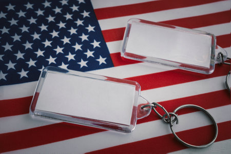 two keychains with an empty white label lies against the background of the American flag. copy space for a design or textの写真素材