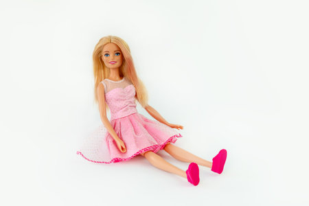 October 9, 2023. Barnaul, Russia: Barbie doll with loose blond hair in a pink dress sitting isolated on a white background.のeditorial素材