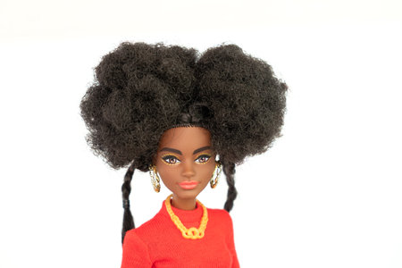 October 9, 2023. Barnaul, Russia: african american Barbie doll with black hair in a red suit standing isolated on a white background.のeditorial素材