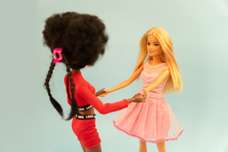 October 9, 2023. Barnaul, Russia: two dolls, a blonde barbie and her African-American friend sitting on a shelf at homeのeditorial素材