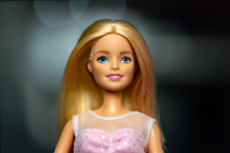 October 9, 2023. Barnaul, Russia: Portrait of a Barbie doll with loose blond hair in a pink dress on a dark background.のeditorial素材