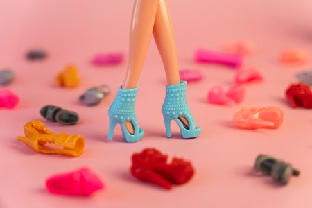 plastic doll legs and a house among a variety of colorful shoes. the concept of the development of the cult of consumption in children.の写真素材