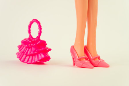 doll in a pink dress on a white background. various accessories for playing with a doll.の写真素材