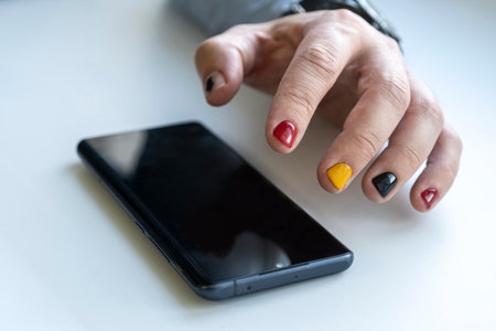 Close up of a man using mobile smart phone. A man with a manicure taps on the smartphone screen.の写真素材