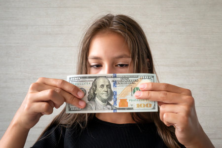 Money, finances and people concept - smiling little girl with dollar cash money. children's moneyの写真素材