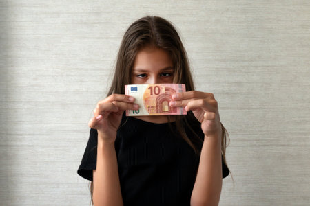 Sad child with money ten euro. Not enough money. white backgroundの写真素材