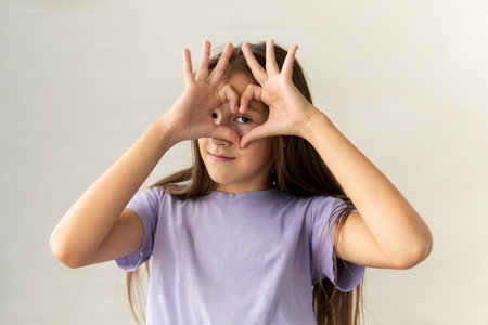 female hands forming a heart shape. A teenage girl shows her heart with her hands.の写真素材