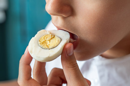 girl eating tasty egg, close up mouth. Health care, loss weight people concept.の写真素材