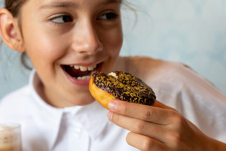Girl Eating Sugary Donut. Girl eating Cake in winter, Portrait of beautiful girl with chocolate donut.の写真素材