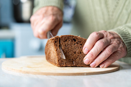 Fresh bread slice and cutting knife on table in the kitchen.