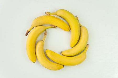 Bananas folded in the shape of a circle lie on white background of the table. top view, above viewの写真素材