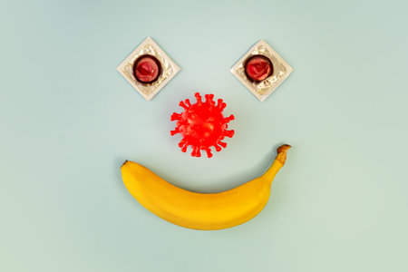 Condom on a banana on a blue background, the concept of protection against sexually transmitted...