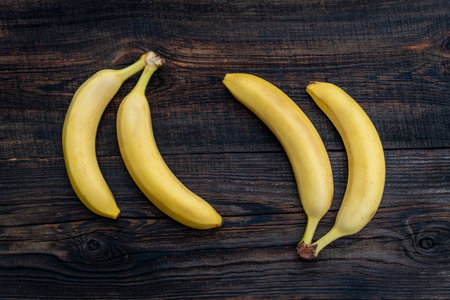 Bananas on a wooden table. a ripe yellow bunch of bananas on the kitchen table. view from aboveの写真素材