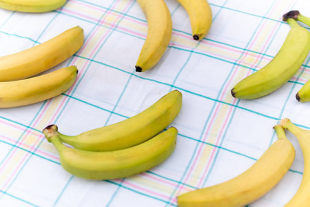 Multiple bananas over white cloth, above top viewの写真素材