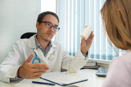 Ache relieve remedy, multivitamins prescription, healthcare and advertising concept. male doctor in white coat showing medications, prescribing medicine giving vitamins bottle to her patientの写真素材