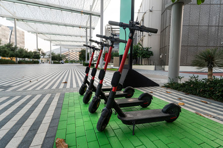 lots of electric scooters scooters in row on parking lot. City bike rental system, public kick scooters on the streetの写真素材