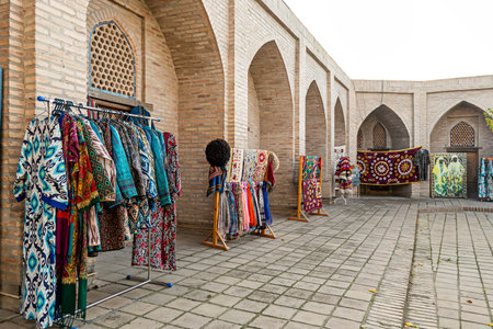 Multicolored national oriental costumes for men and women and carpets on the street near souvenir...