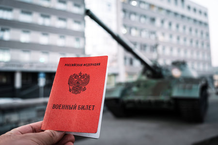 Title: Russian Federation, military ID. Russian Federation, military ID in hand on background of a tankの写真素材