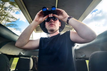 guy with the binoculars against the background of the nature. Observation of birds. Birdwatching....