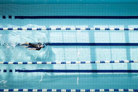 Swimmer floating in the swimming pool, top view. Man swimming on back. Swimming on the back, crawling on the backの写真素材